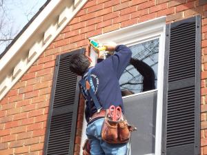 repairman putting sealant around a home window