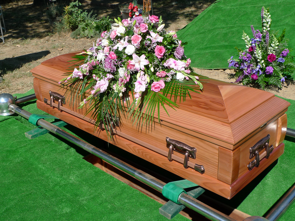 Wood casket with white and pink flowers