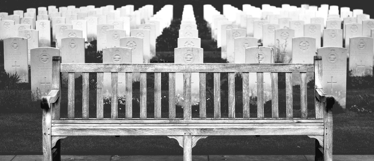 Bench in front of headstones in cemetery